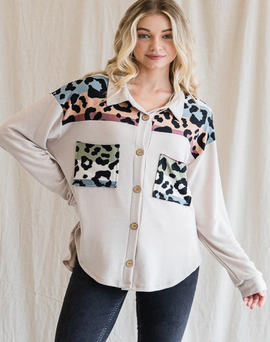 Frontal view. Cream colored button up shacket with multicolor animal print detail.